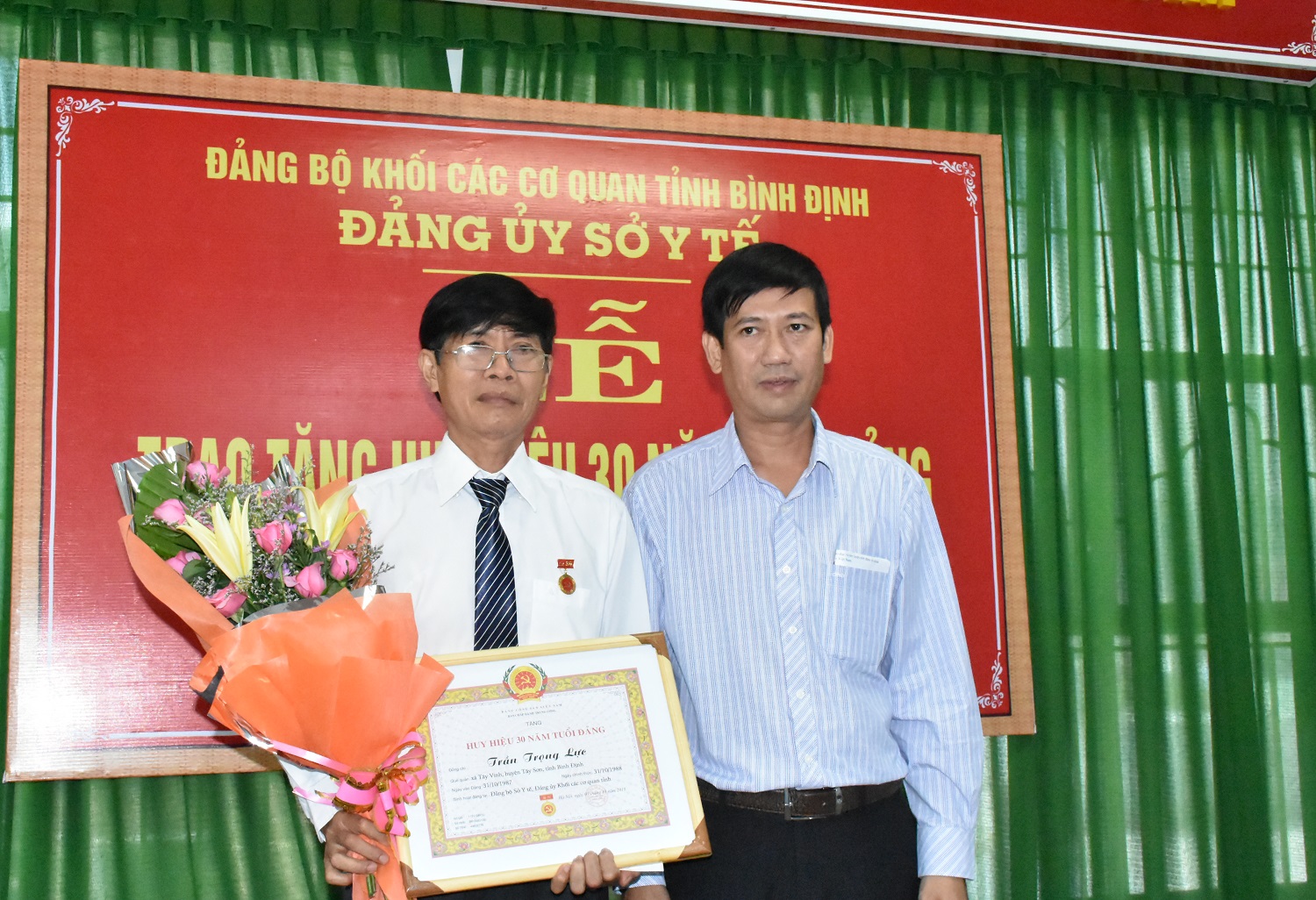 Đồng chí Nguyễn Hữu Lộc, Phó Bí thư Đảng uỷ Khối các cơ quan tỉnh trao Huy hiệu 30 năm tuổi Đảng cho đồng chí Trần Trọng Lực