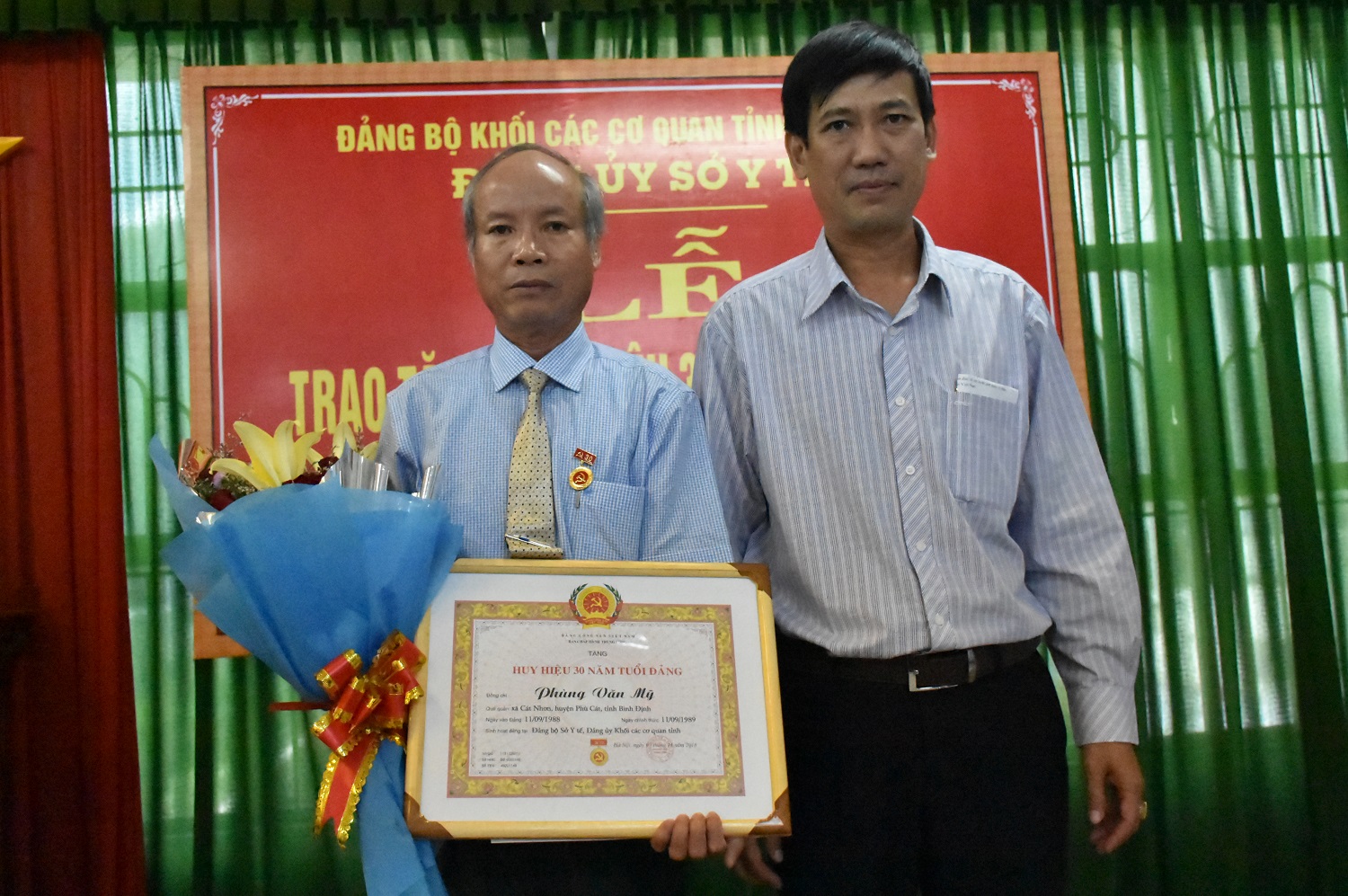 Đồng chí Nguyễn Hữu Lộc, Phó Bí thư Đảng uỷ Khối các cơ quan tỉnh trao Huy hiệu 30 năm tuổi Đảng cho đồng chí Phùng Văn Mỹ
