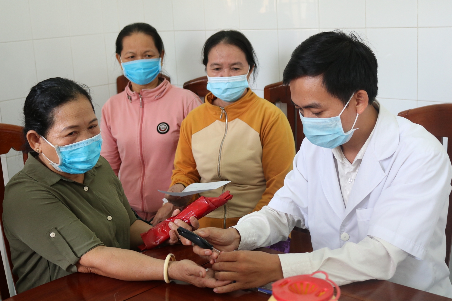 Nhân viên y tế xét nghiệm nhanh đường huyết cho người bệnh đái tháo đường (ảnh Thu Hiền)