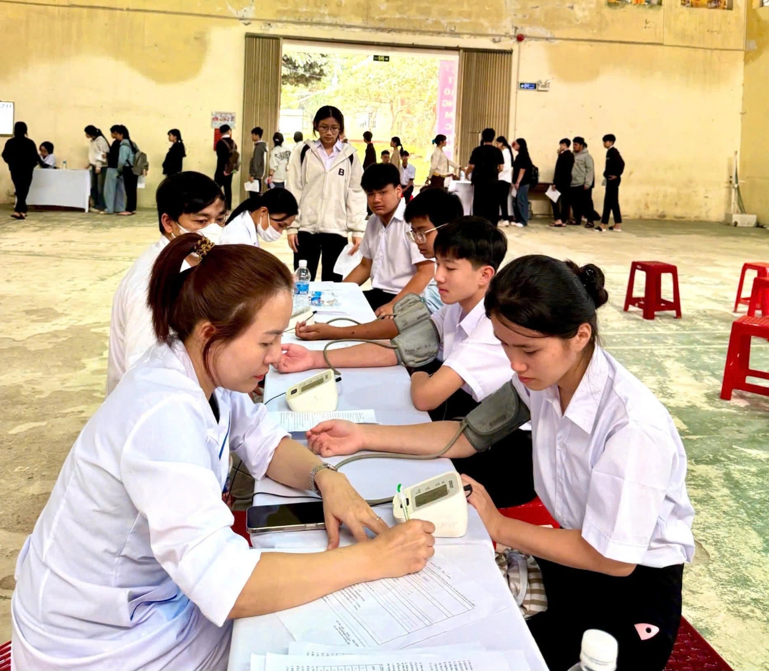Học sinh được kiểm tra mạch và đo huyết áp trong bước khám thể lực tổng quát.